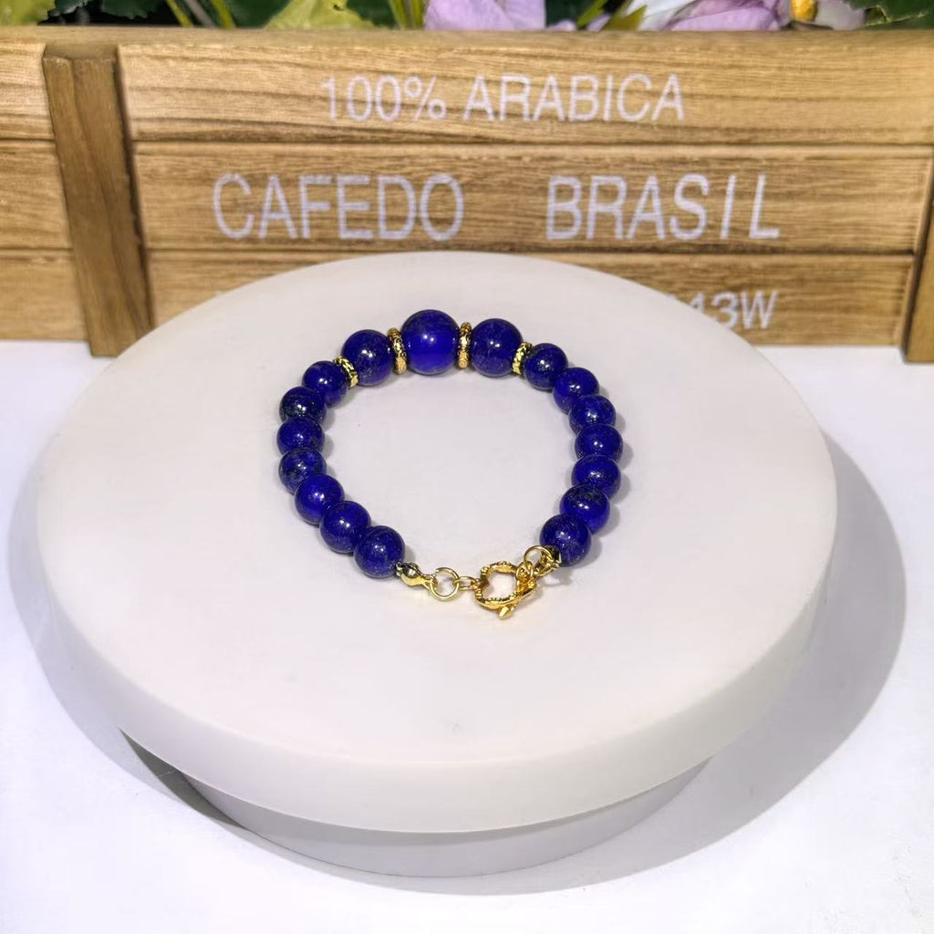 Empress Trio statement gemstone bracelet featuring three large 12mm deep blue Afghan Lapis Lazuli focal beads separated by ornate gold wheel spacers and finished with an intricate gold heart toggle clasp.