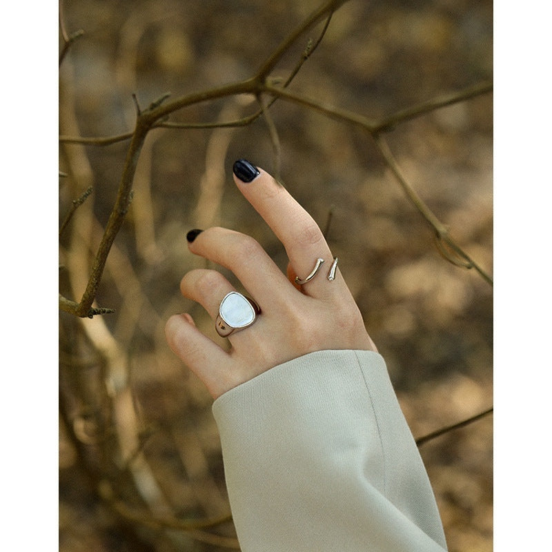 BoxUnboxed Iris geometric statement ring in sterling silver with pearlescent inlay on a hand.