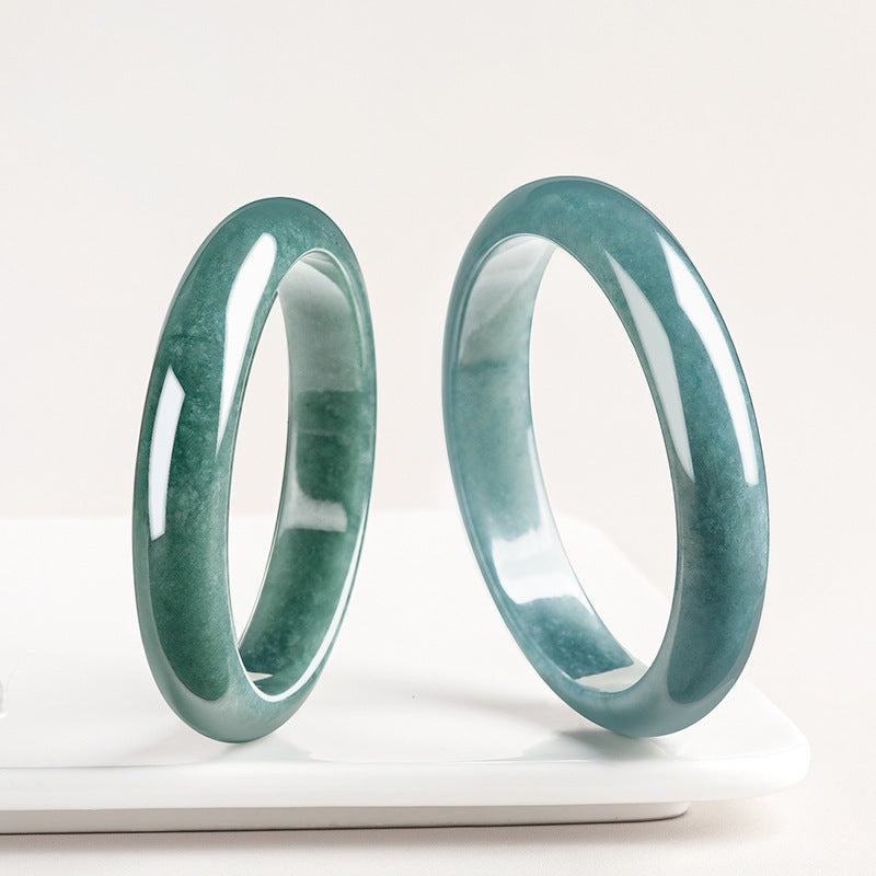 BoxUnboxed Meridian Natural Blue Water Jadeite Bangle, a smooth, translucent ocean-teal gemstone bracelet with a high-gloss finish.
