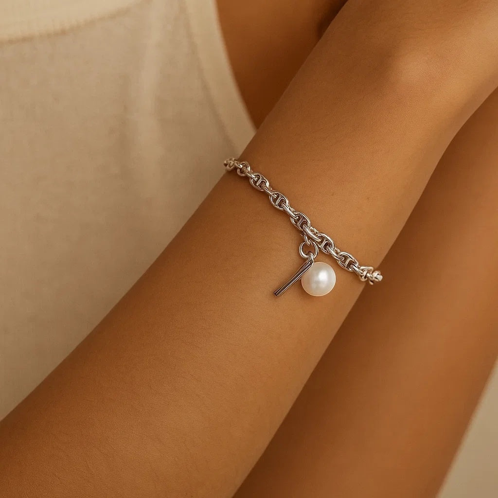 BoxUnboxed sterling silver anchor link bracelet with pearl charm and toggle clasp on a wrist.