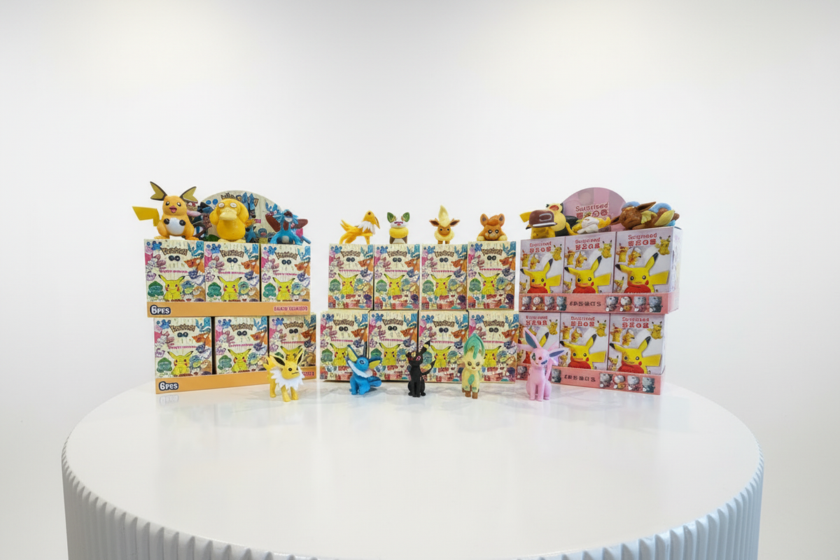 A collection of Pokémon blind box displays and figurines arranged on a round white pedestal against a clean white studio background. Multiple boxes featuring Pikachu and other Pokémon characters are stacked, with several small toy figures placed in front.